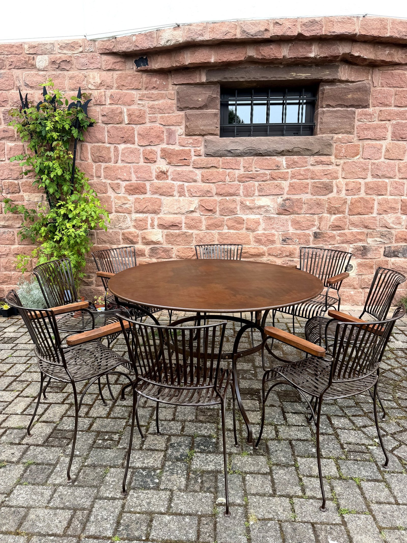 Table ronde et chaises en fer forgé dans un jardin